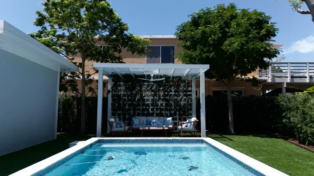 Poolside pergola with lounge seating and artificial turf in the Florida Keys